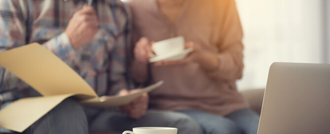 Family holding a cup of coffe looking at financial documents.